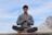 man meditating on brown wooden platform during daytime