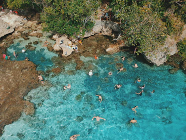 Tourists enjoying a refreshing swim in the turquoise waters of the Emerald Pool.
