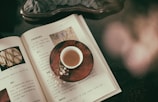 An open book with a cup of tea beside it.