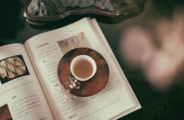 An open book with a cup of tea beside it, representing knowledge and relaxation.