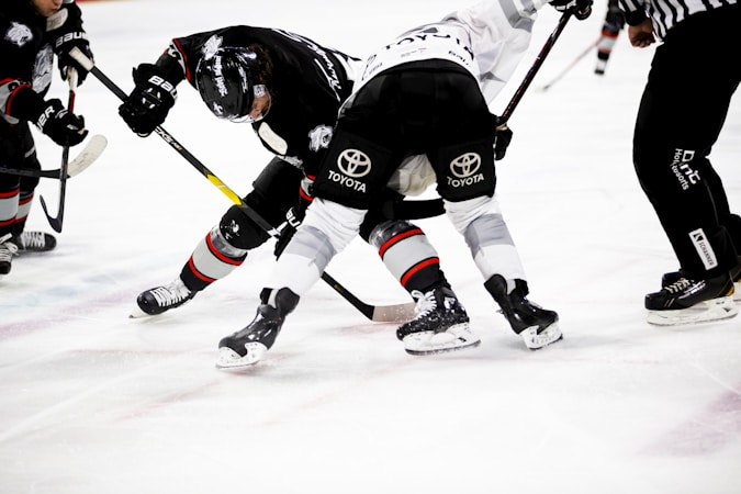 Hockey players lined up on the ice as spectators watch from the seats