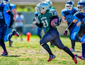 Flag football players sprinting down the field with vibrant jerseys in motion.