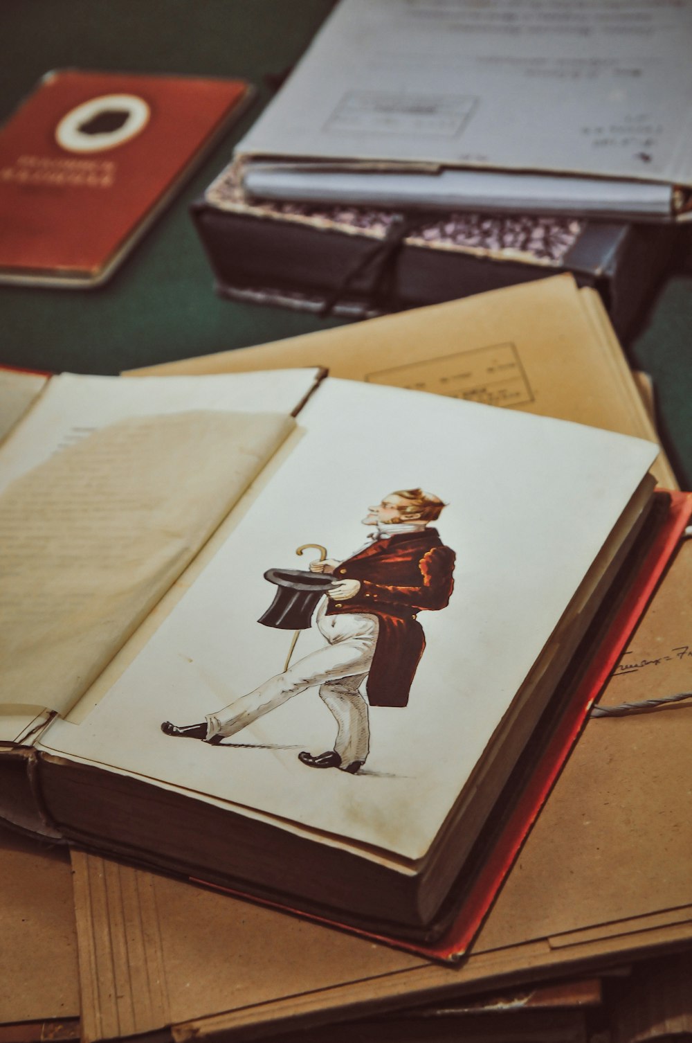 man wearing suit while holding top hat book picture