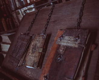 three closed brown books on brown wooden surface