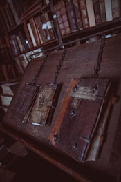 three closed brown books on brown wooden surface