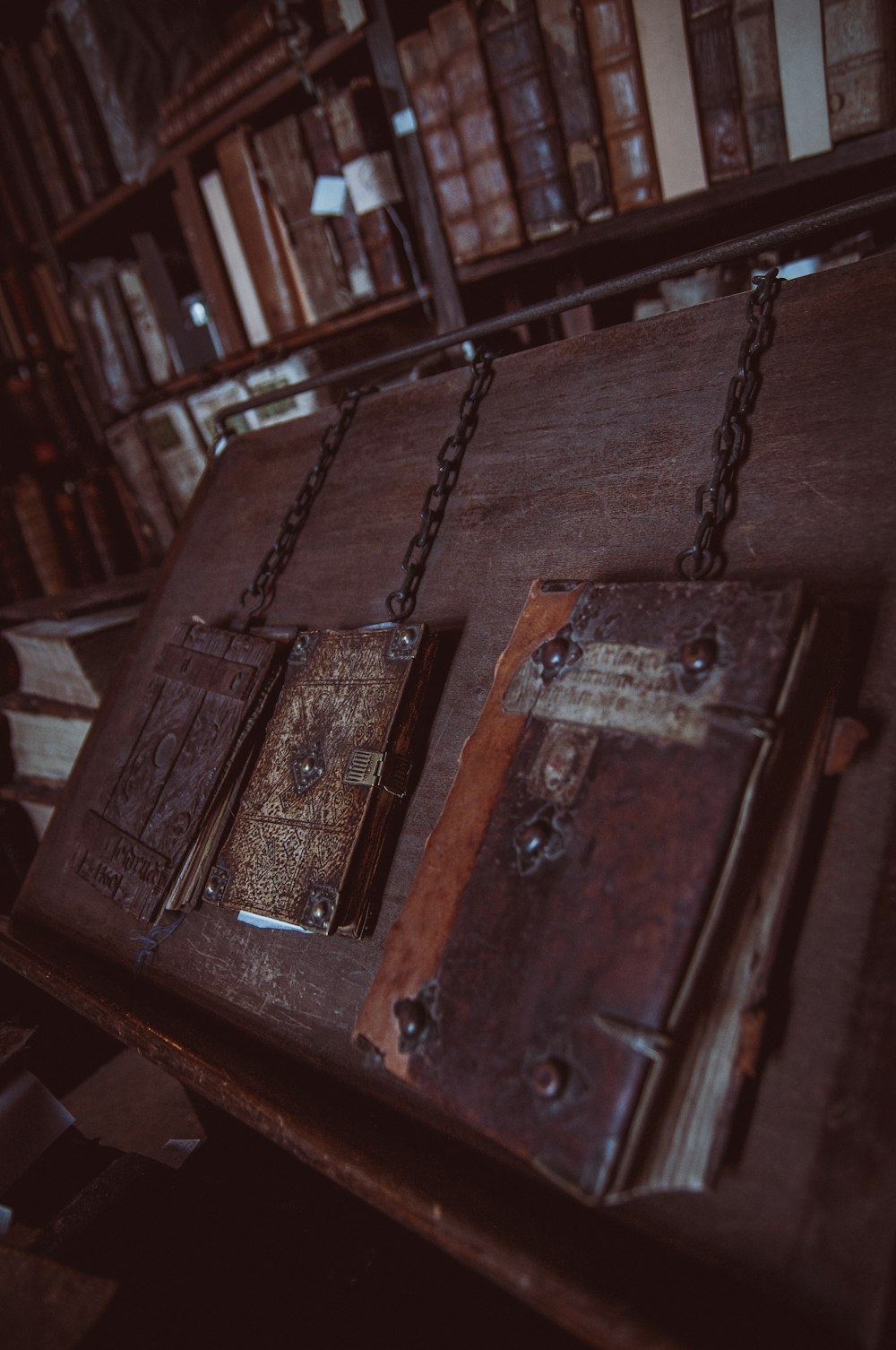 three closed brown books on brown wooden surface