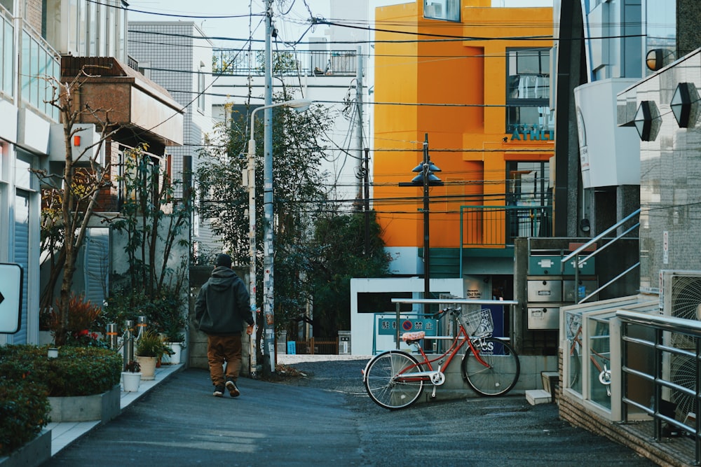 red bicycle near man wearing gray coat