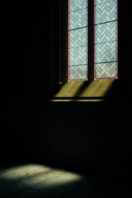 Soft light filtering through stained glass, casting colorful patterns