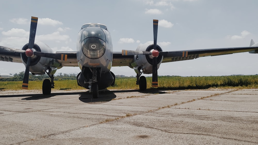 grey twin engine bomber plane on tarmac under cloudy sky