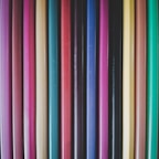 Close-up of colorful pens and pencils neatly arranged in holders on a desk.
