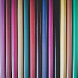 Close-up of colorful pens and pencils neatly arranged on a wooden desk.