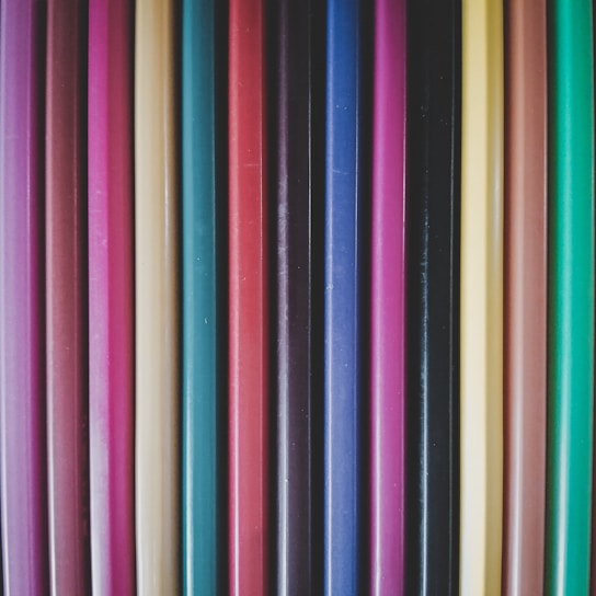 Close-up of a variety of colorful pencils arranged neatly on a wooden desk.