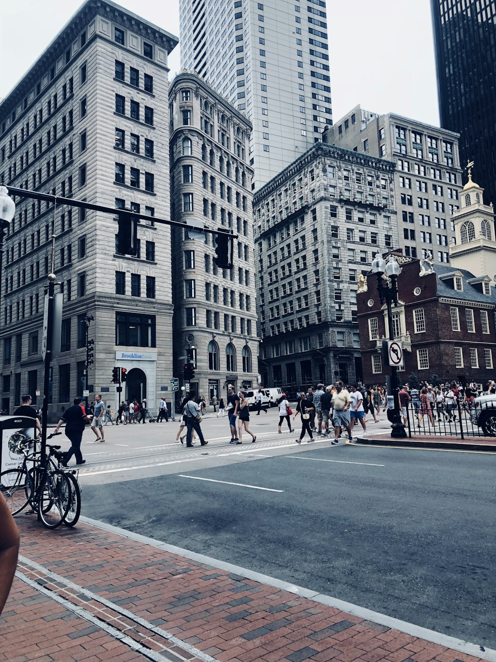 people walking on street crossing near grey tall buildings