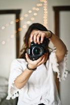 woman holding black DSLR camera