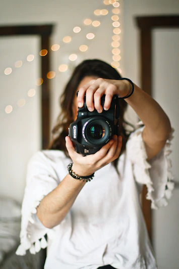 woman holding black DSLR camera