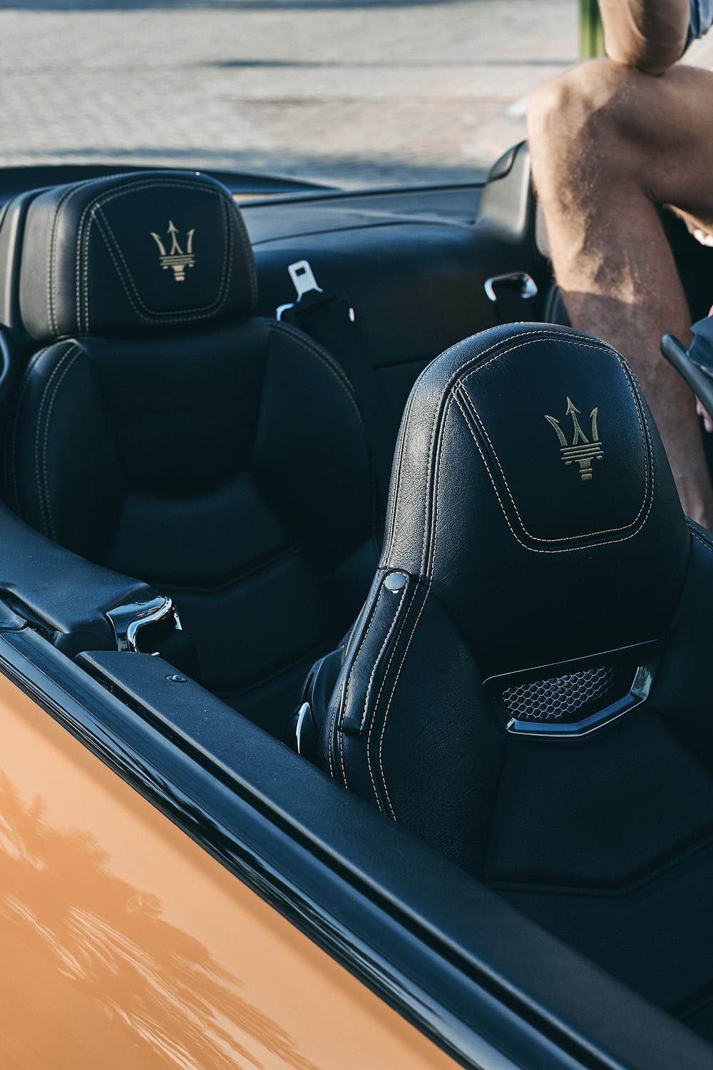 person sitting on Maserati convertible vehicle during daytime