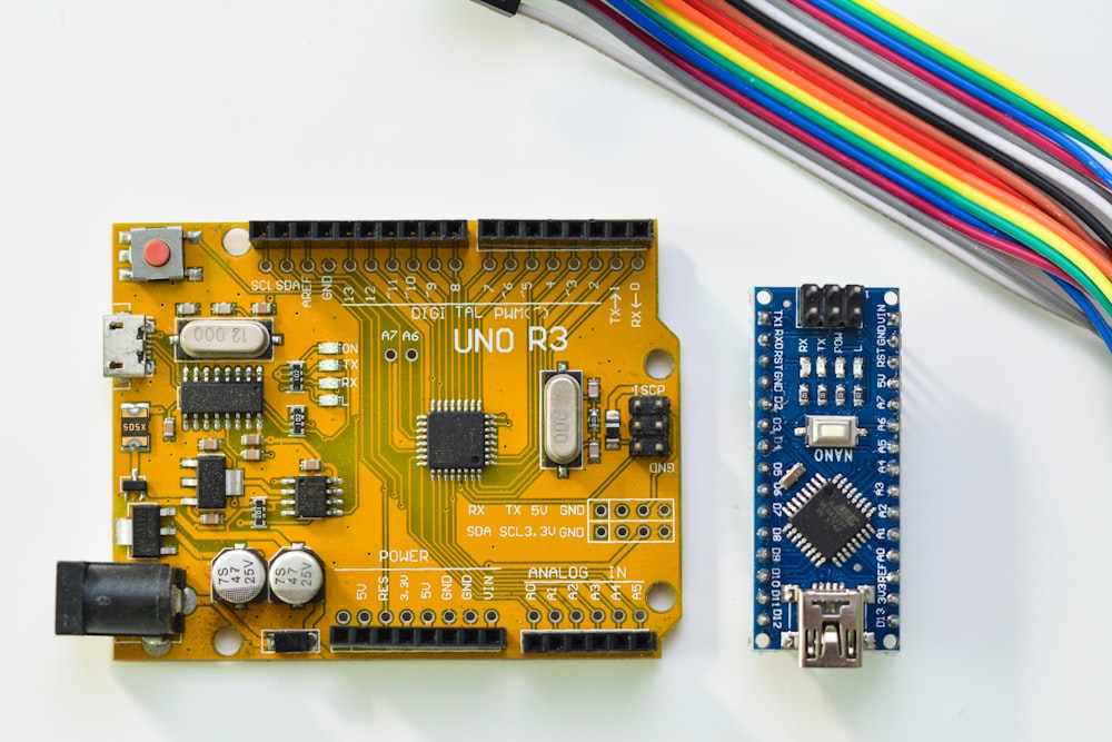 two brown and blue circuit boards with colored wire at upper side