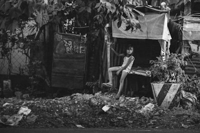 grayscale photography of girl sitting under tree