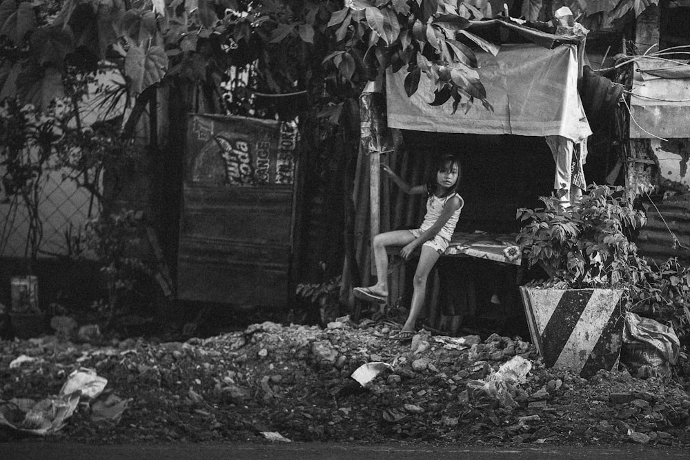 grayscale photography of girl sitting under tree