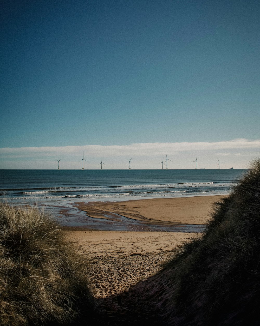 windmills near body of water