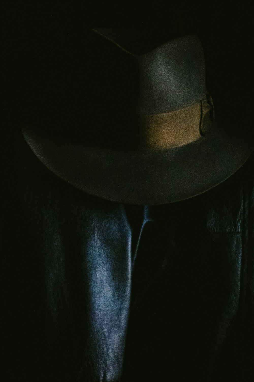 Grauer Fedora-Hut auf schwarzem Textil