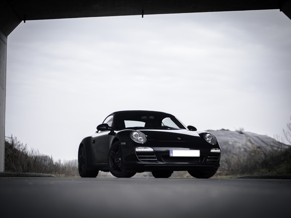 black coupe on gray road during daytime