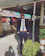 A stylish man wearing a tailored dark blazer, smiling confidently in a sunlit urban setting.