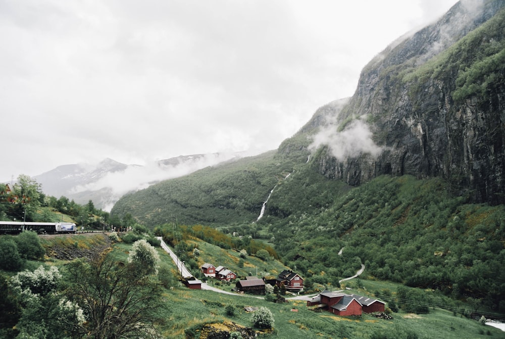 houses near green mountain during daytime