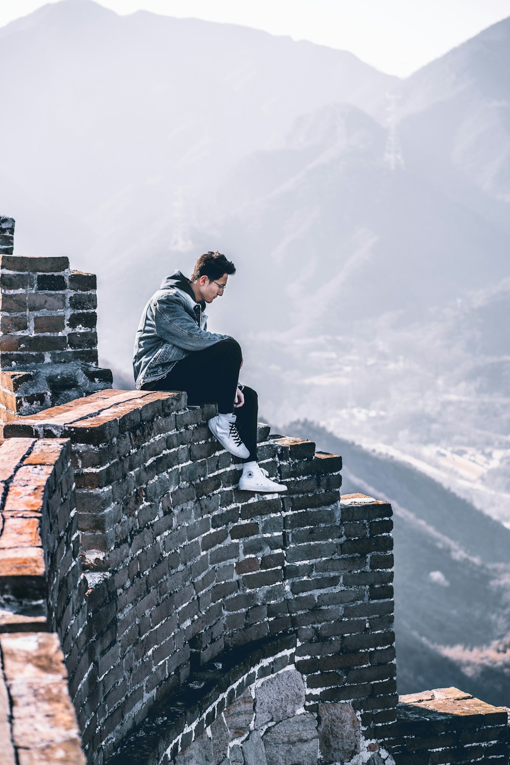man sitting top of wall