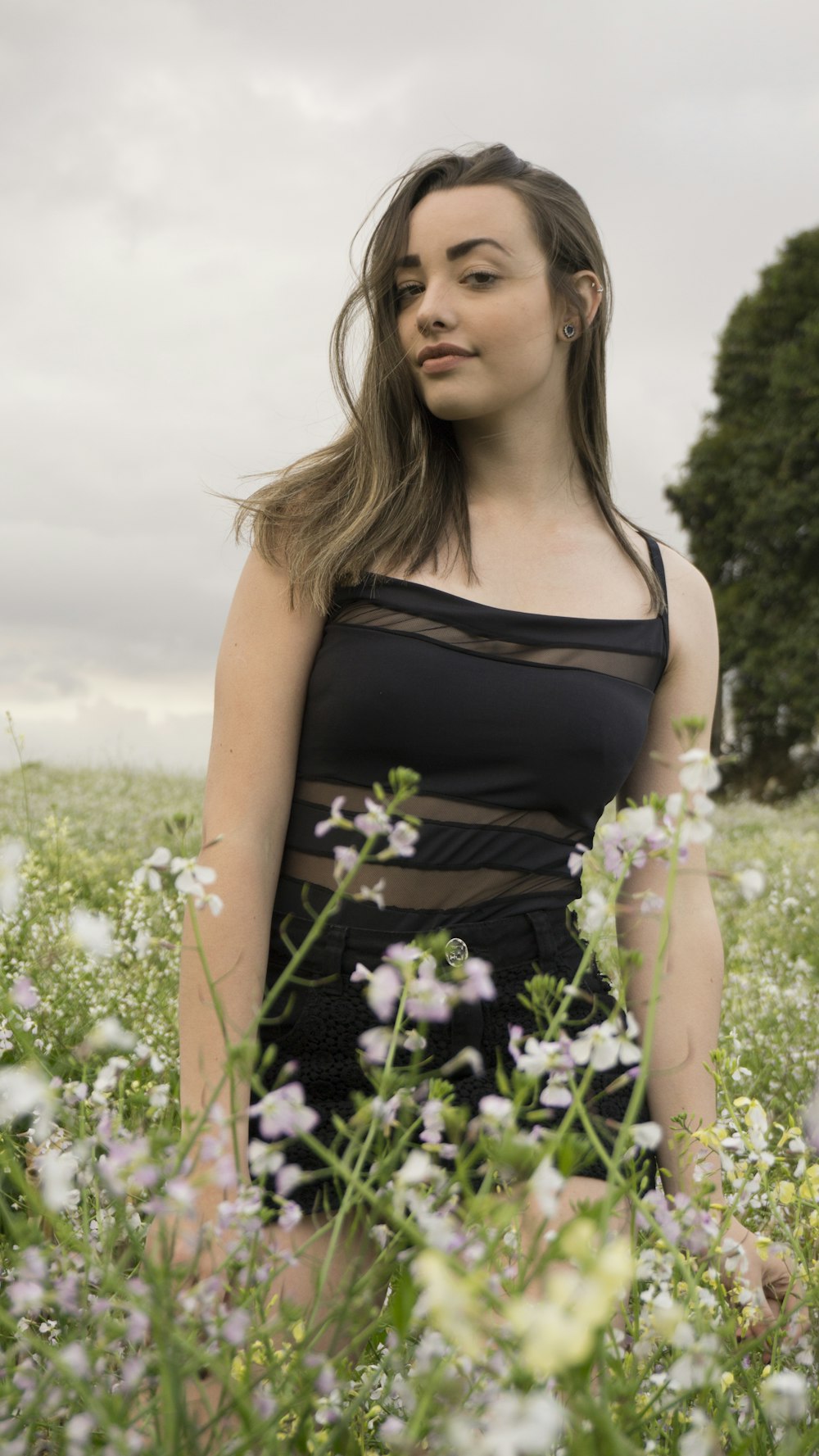 woman wearing black top standing on white flower field