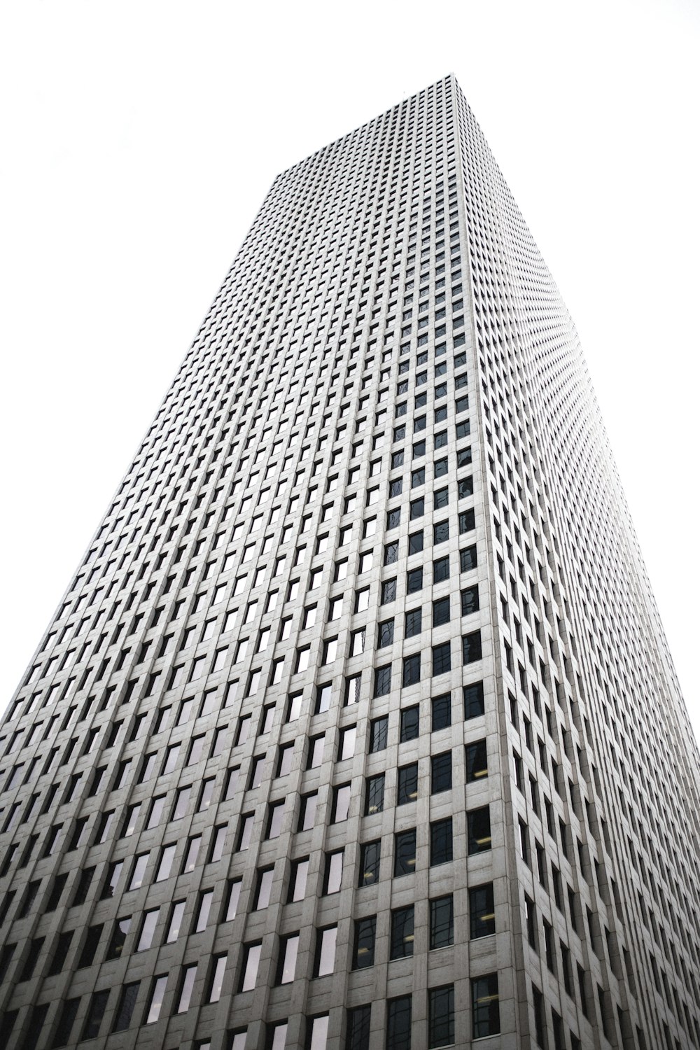 Photographie en contre-plongée d’un immeuble gris de grande hauteur