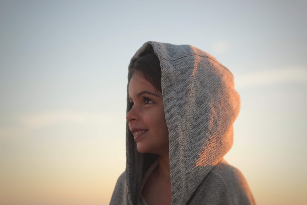 girl wearing gray hoodie while smiling