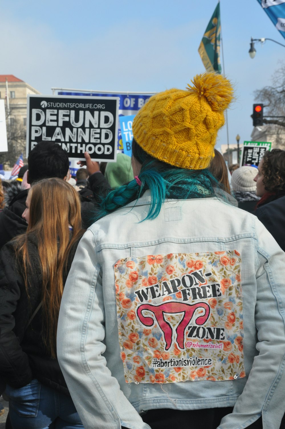 woman in yellow bobble hat standing in crowd