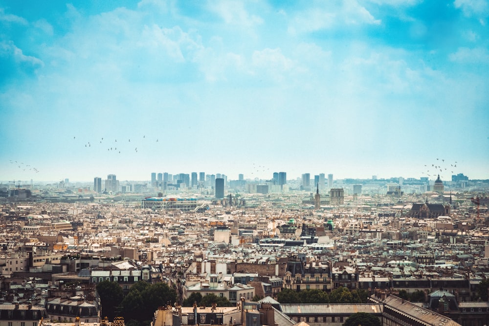 aerial photography of city under white clouds and blue sky