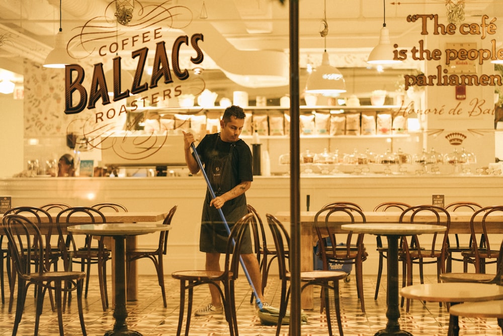 man mopping floor of Coffee Balzac's roaster