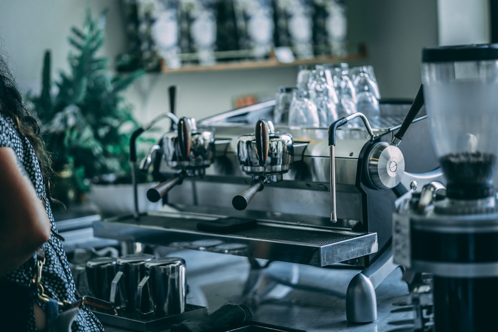 person standing near coffee machine inside room