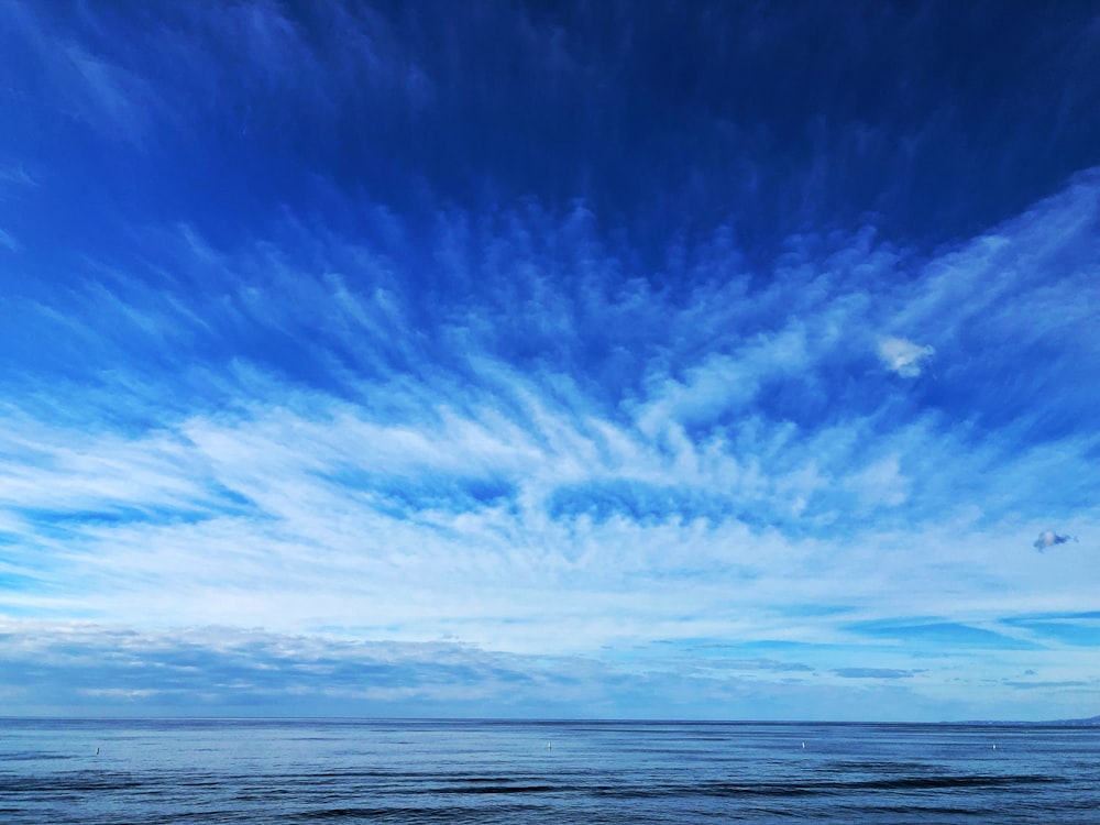 mar calmo sob céu azul e branco