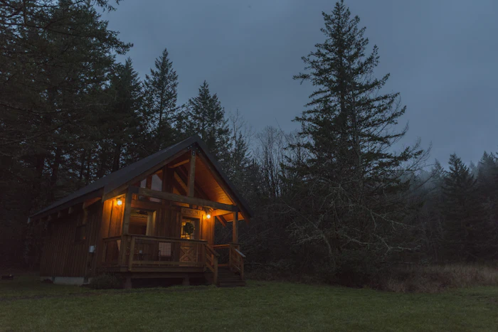 Cabaña del Bosque con las luces encendidas entre los pinos