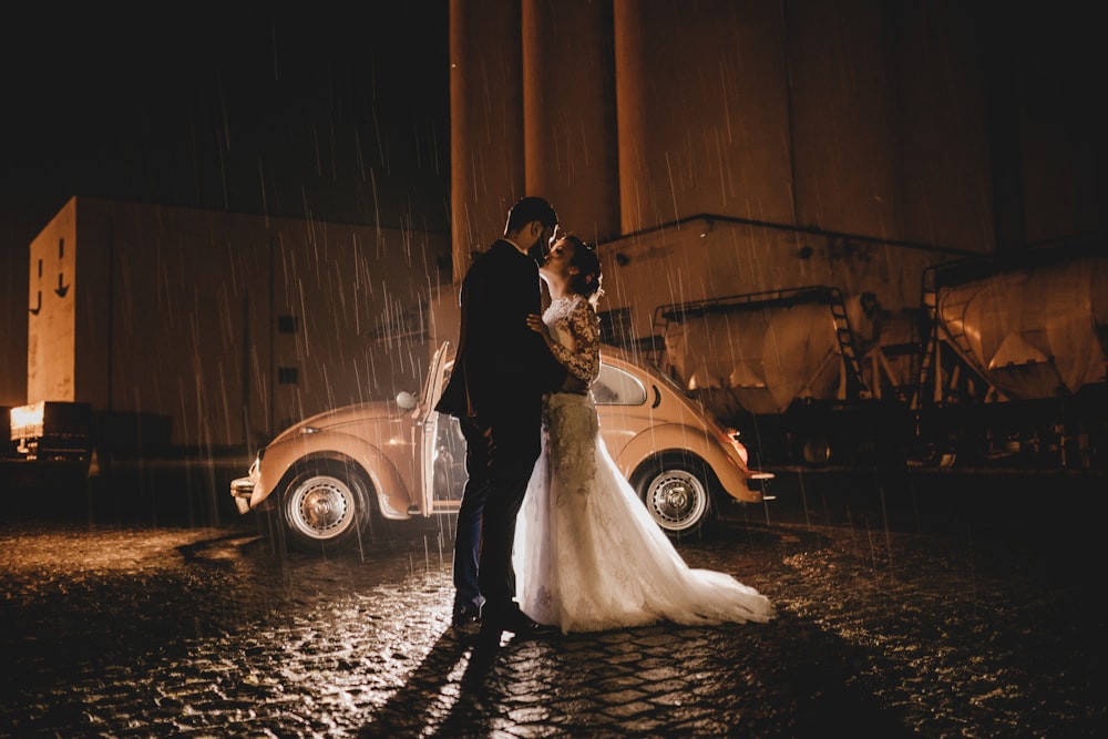 couple kissing near vehicle during nighttime