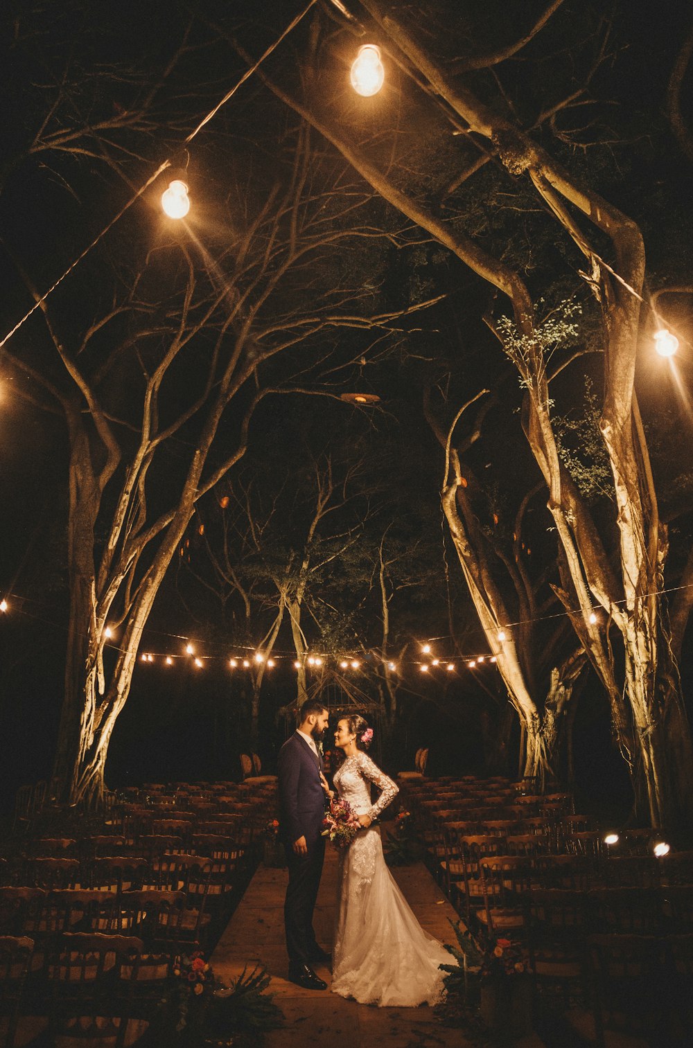 夜のライトアップされた木の下でカップル