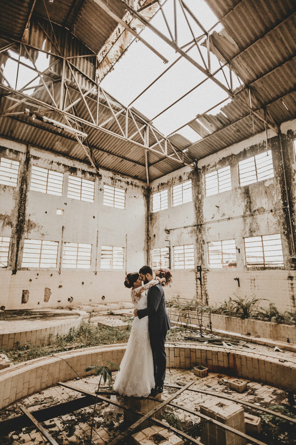 man and woman face to face while standing inside abandoned concrete house