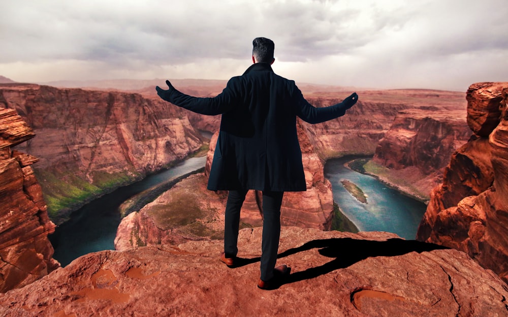 man standing on peak at daytime