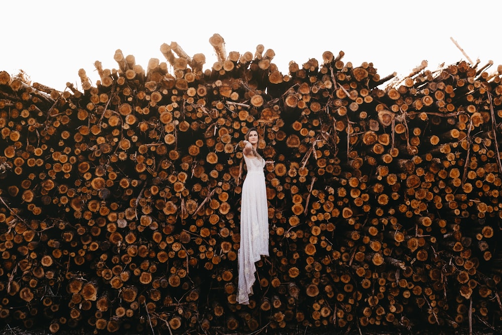 woman standing in front of wood logs