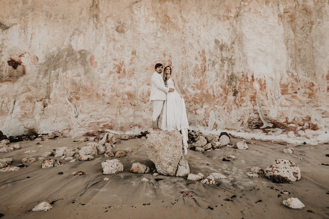 man and woman standing front of rock formation