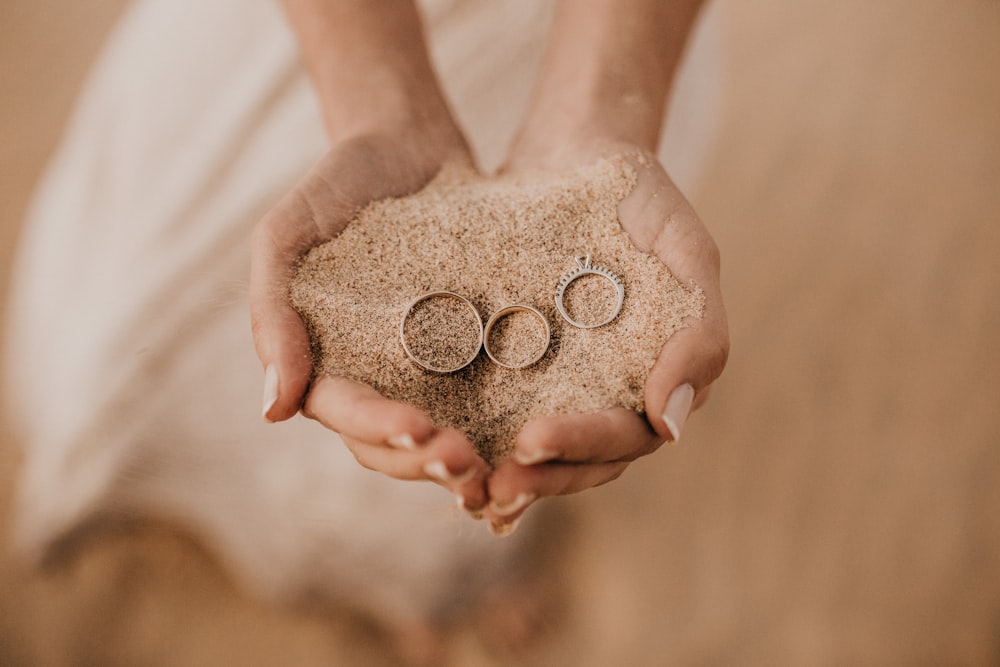 person hold sand with three rings on top