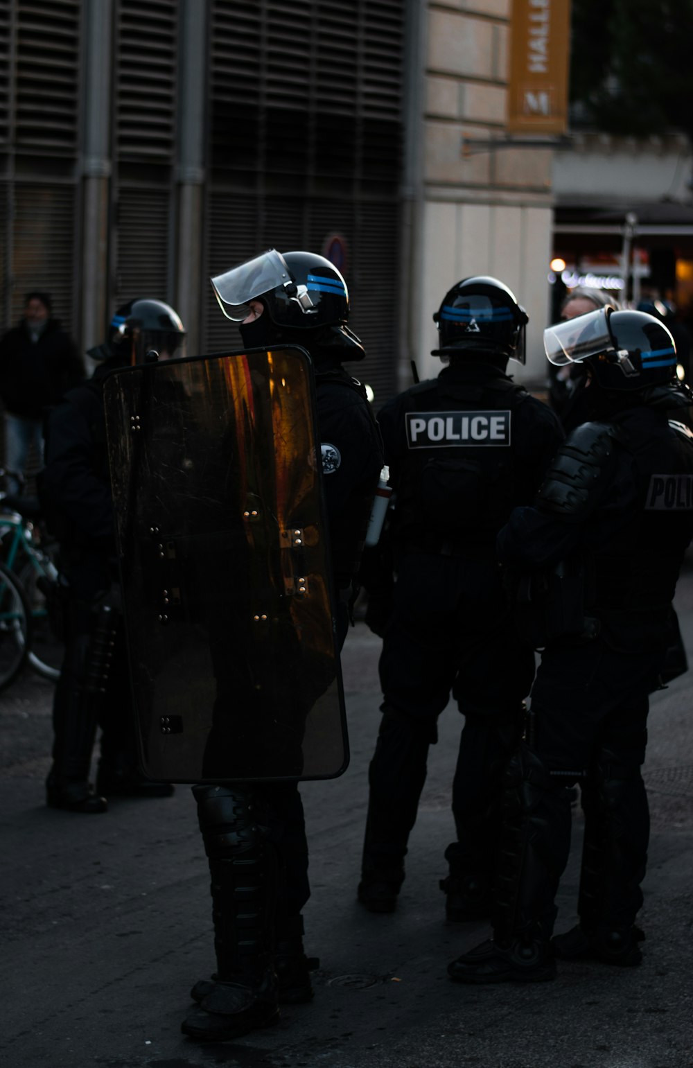 hombres con uniformes de policía parados afuera de los edificios durante el día