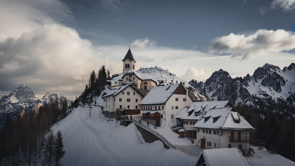 white houses beside snow covered pine trees