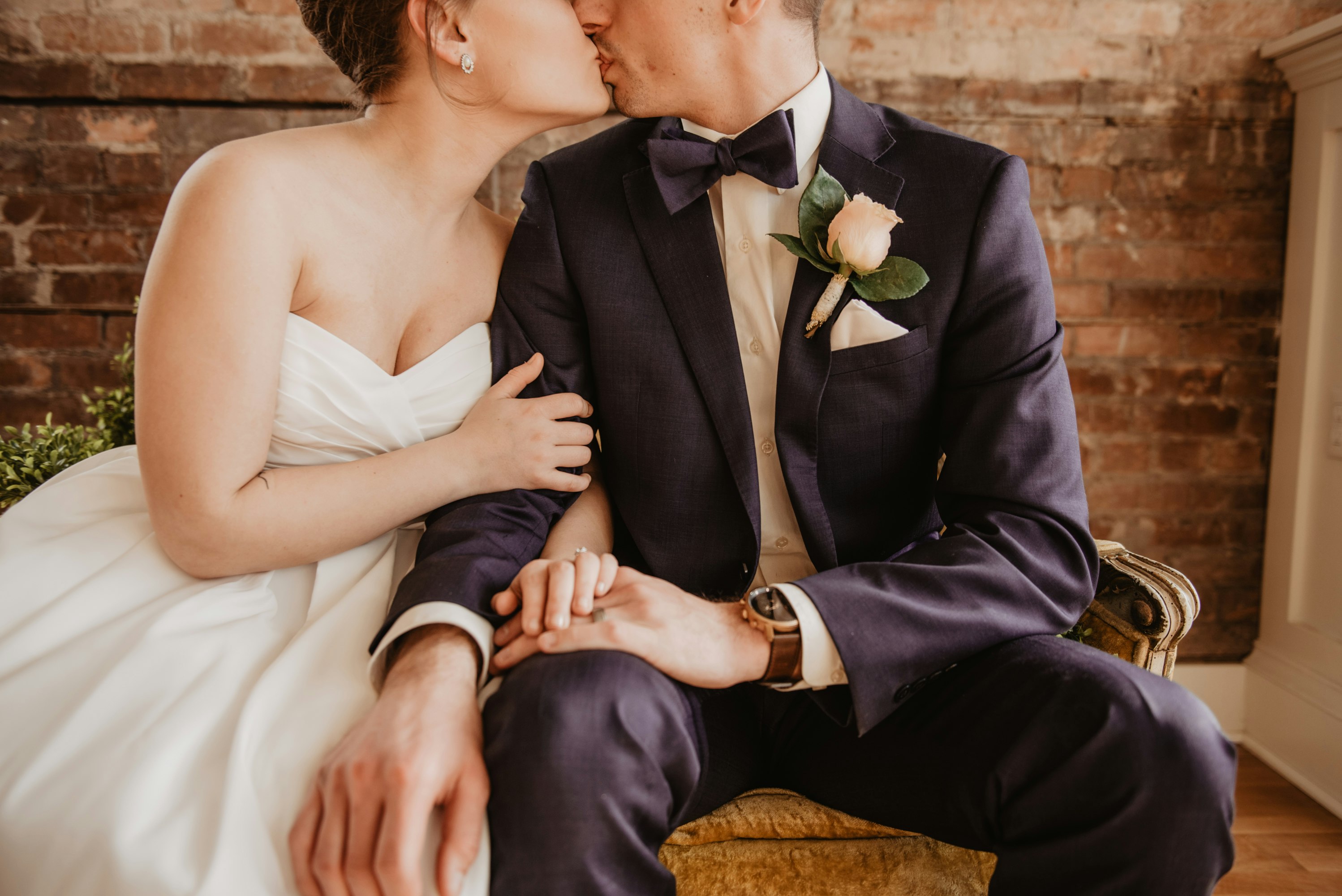 sitting bride and groom kissing
