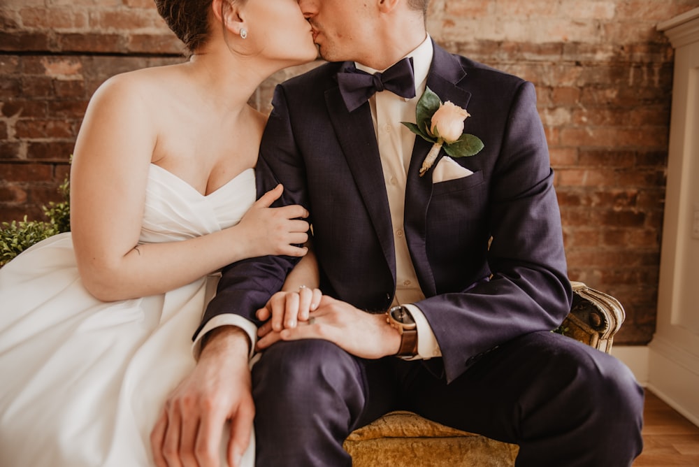 sitting bride and groom kissing