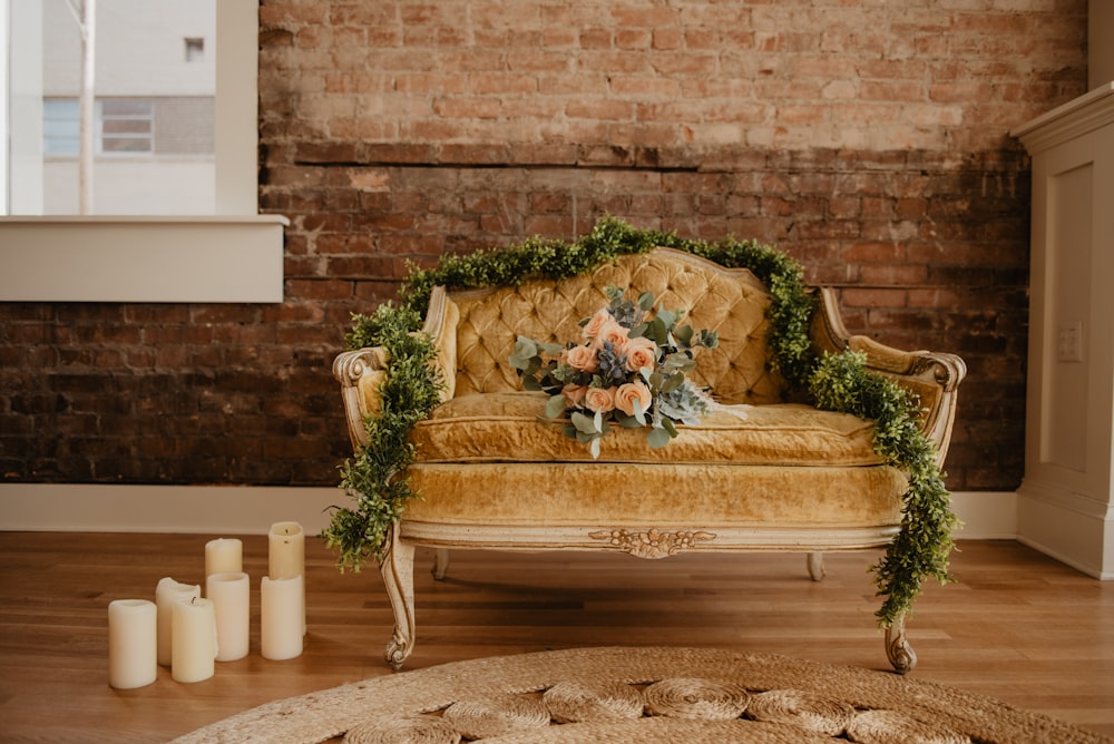 vacant tufted beige loveseat with bouquet of orange rose flowers